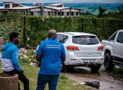 2022_South Africa_Male monitor speaking to potential male victim or trafficker at bus stop_WS (3) copy