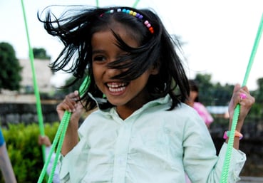 girl_smiling_swinging_family_home_early_years