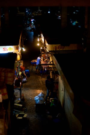 a dark street in Asia, empty but for two people