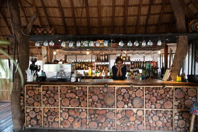 Girl rests chin on hands and leans over the bar top