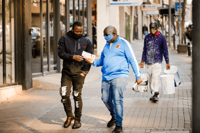 Monitor hands a brochure about human trafficking to a passerby.