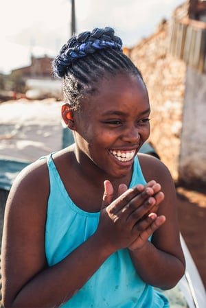 african girl smiling wearing blue shirt