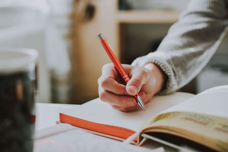 Person writing with a pen on paper