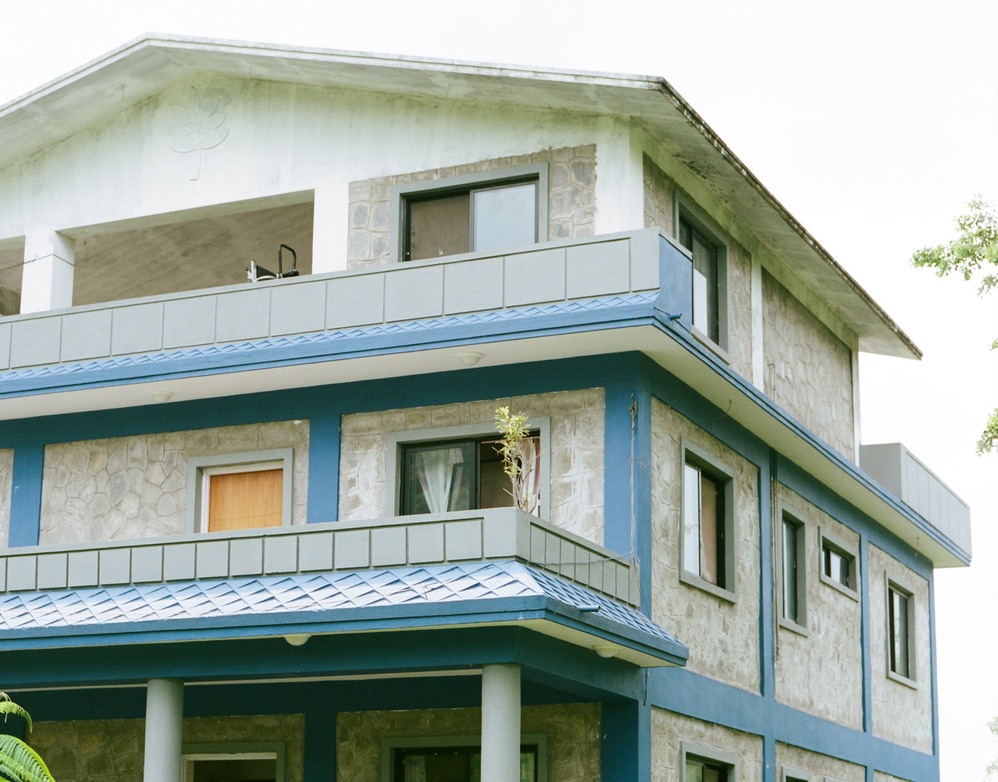 Large three story blue and white house with balconies