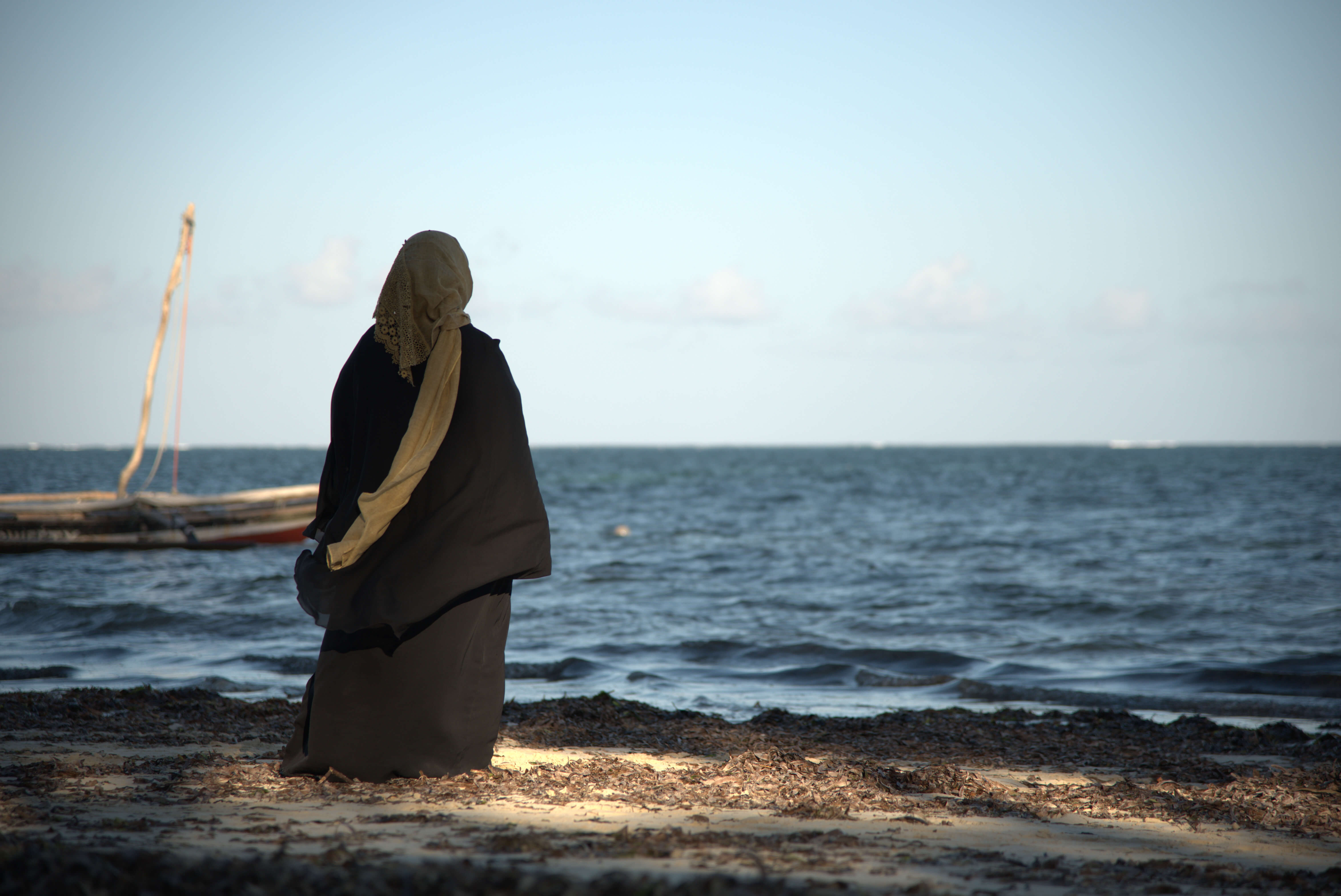 Human trafficking survivor stands at the shoreline