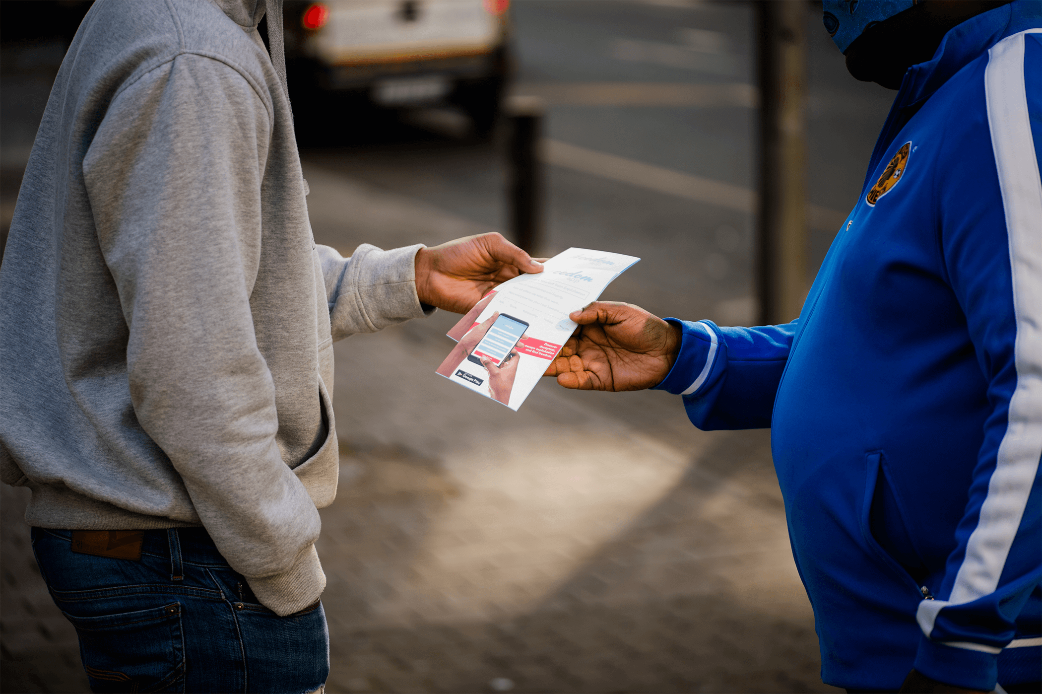 Man hands someone a brochure about human trafficking as part of the Freedom Project.
