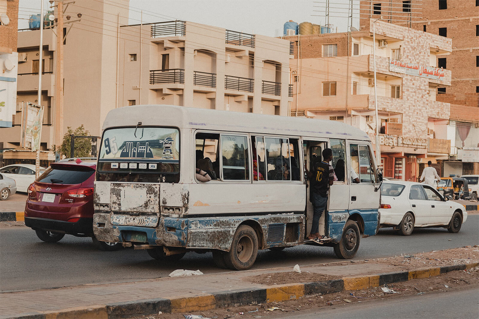 Teenage boy hanging off a bus