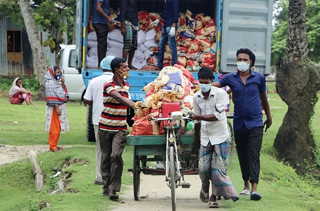 A person pushes a bike loaded with COVID relief provisions